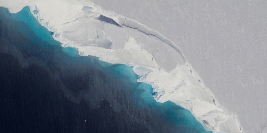 Thwaites Glacier aerial photography, ocean water and melt water mixing, icy blues and bright whites, iceberg cracks